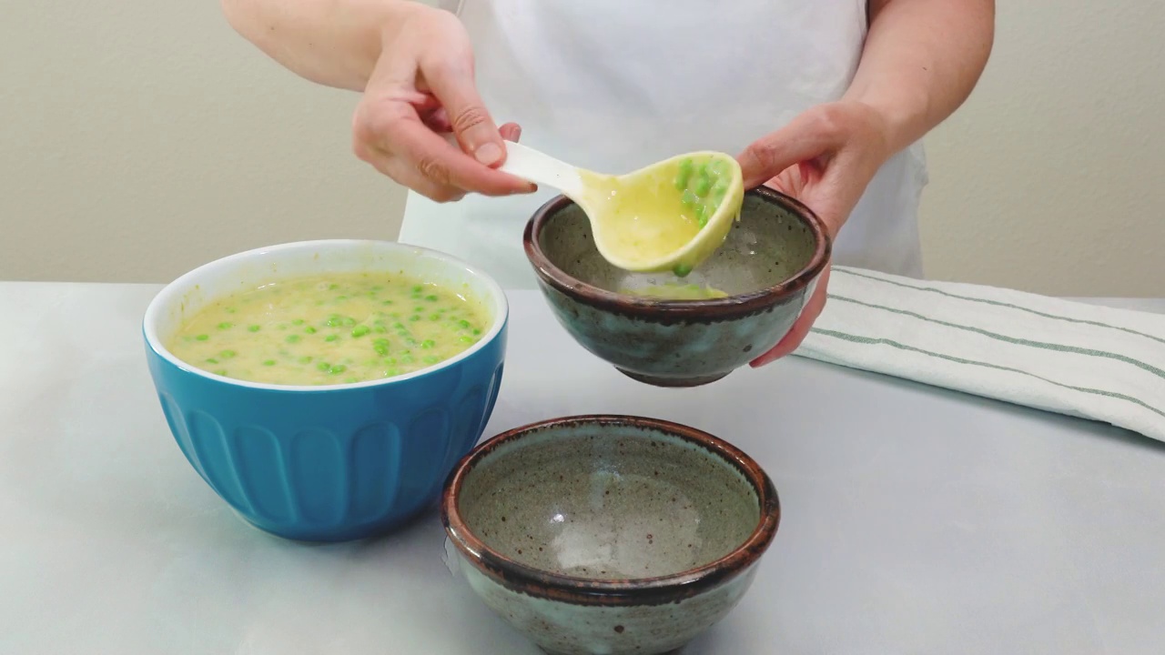 奶油芹菜浓汤配新鲜青豆食谱。女人服务餐视频素材