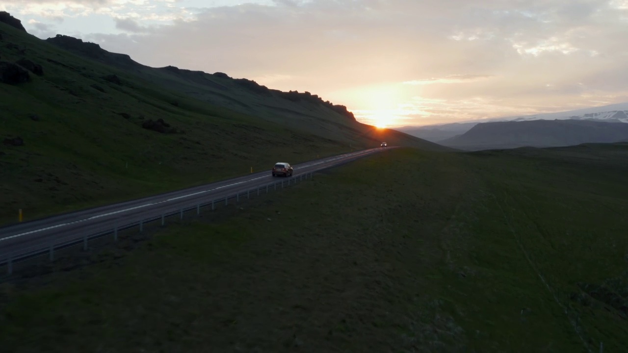 冰岛环城公路鸟瞰图，日落时分汽车快速行驶。在傍晚的黄金时间里，高速公路上的汽车安静地行驶着，从空中俯瞰视频素材