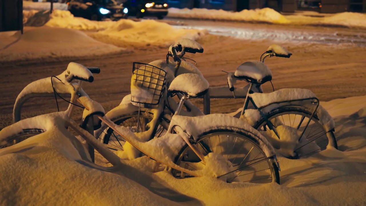 冬夜，市中心自行车停车场的自行车被雪覆盖视频素材