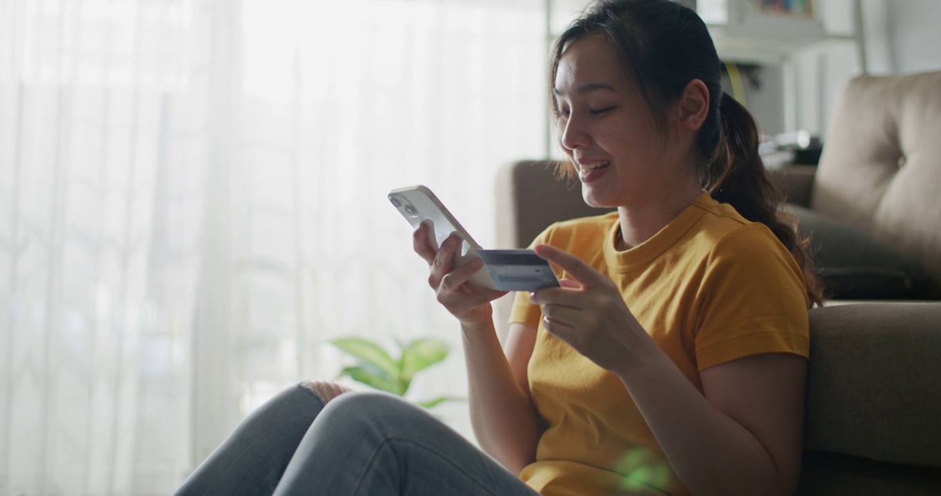 亚洲女性在家用智能手机网购视频素材