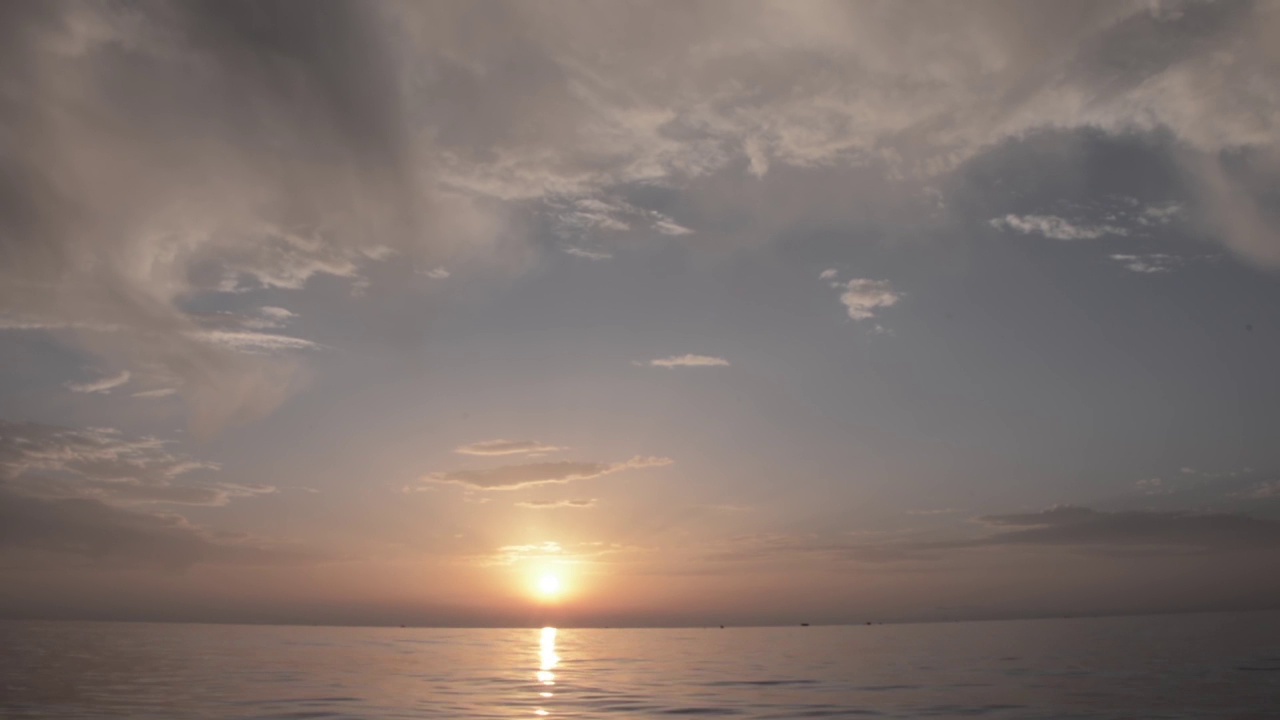 日出的海边，漂浮着几艘渔船视频素材