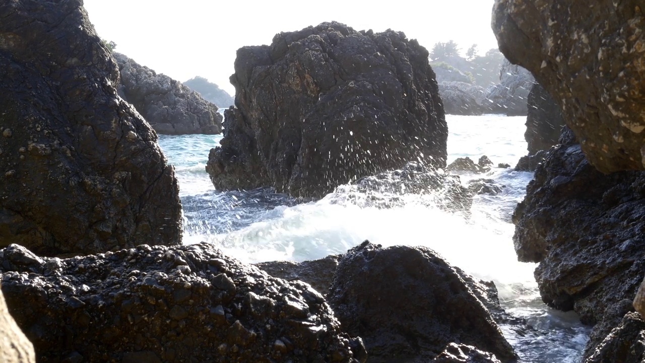 波浪拍打着陡峭的卵石海岸，溅起了水花视频素材