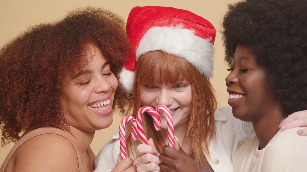 不同种族的女人拿着圣诞糖果大笑视频素材
