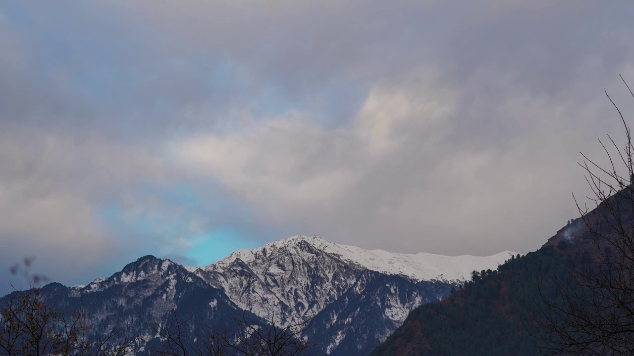 在印度喜马偕尔邦的马纳里，4K延时拍摄了早晨被积雪覆盖的山。清晨的黄光照射在被雪覆盖的喜马拉雅山脉的山顶上，把它变成了橙色。视频素材