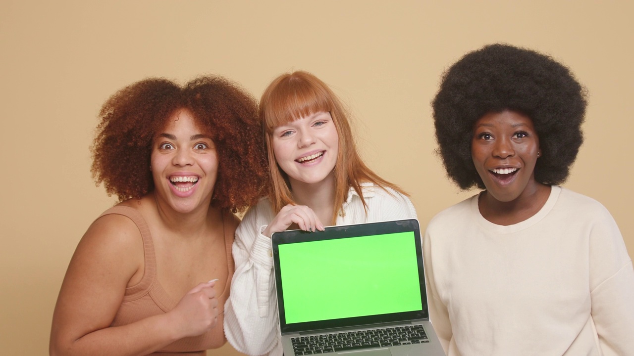 女友们惊讶地看着笔记本电脑的绿色屏幕视频素材