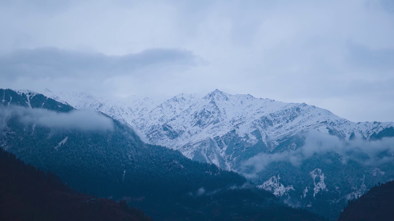 在印度喜马偕尔邦的马纳里，冬天的时候，积雪覆盖的山脉上空的冬季乌云的延时拍摄。冬季喜马拉雅山脉的云朵延时。视频素材