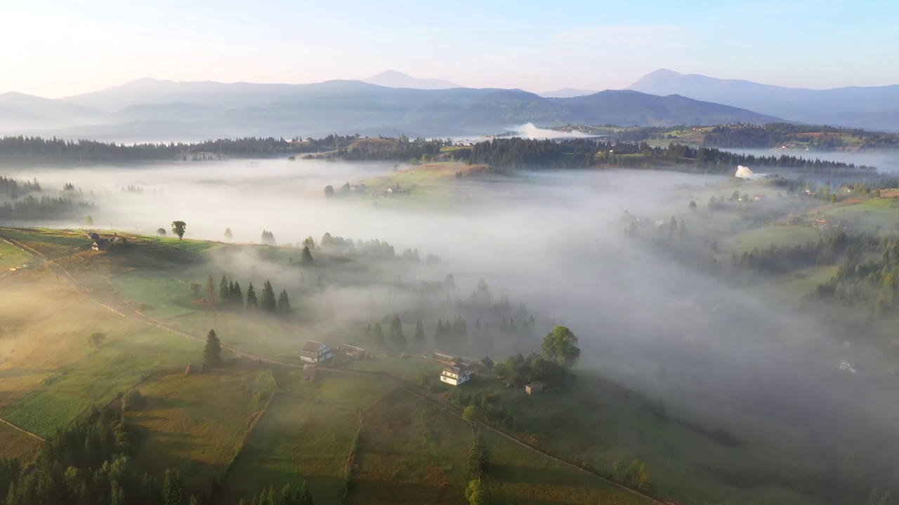 一架无人机在日出时飞过一个风景如画的雾蒙蒙的山谷。视频素材