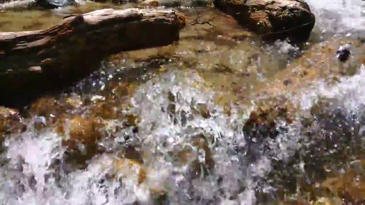 纯净的水在石头之间流动。山河汹涌的水流越来越近视频素材