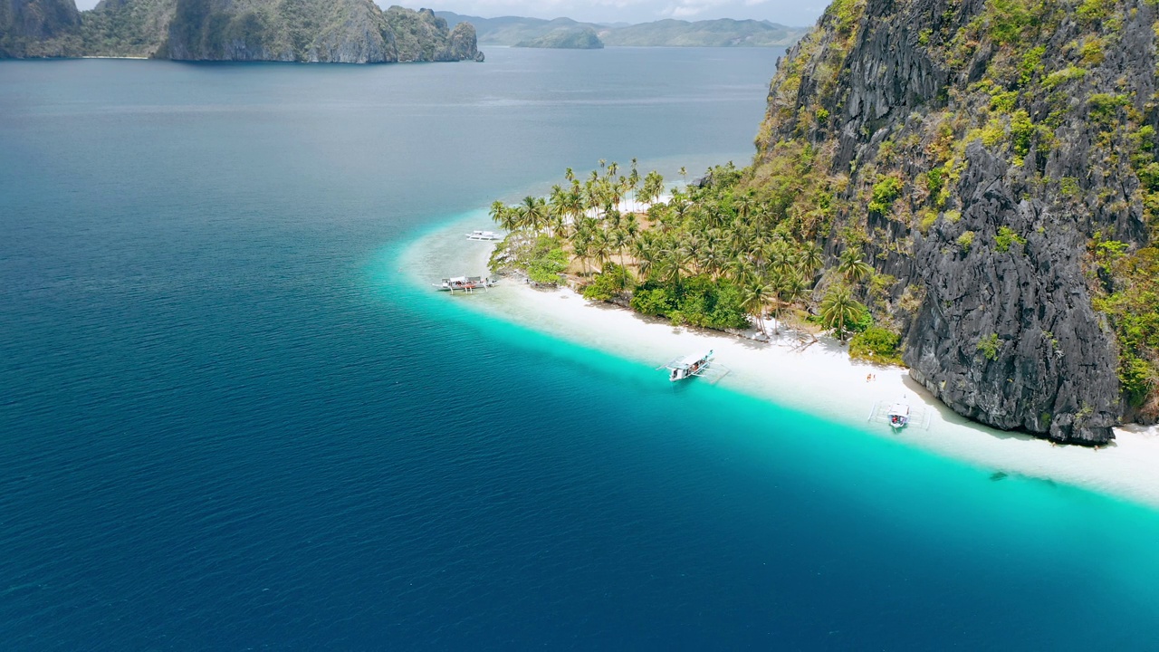 无人机拍摄的热带Ipil海滩，pinagbuutan岛，El Nido, Palawan，菲律宾。碧蓝的海水、沙滩和棕榈树——度假、旅游的旅游概念视频素材