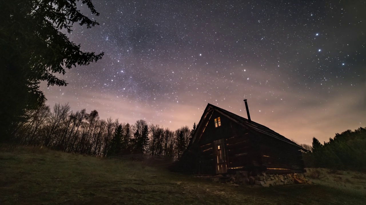 神奇的夜空与星星，银河系和云快速移动古老的木屋在野生喀尔巴阡自然天文时间推移4K视频素材