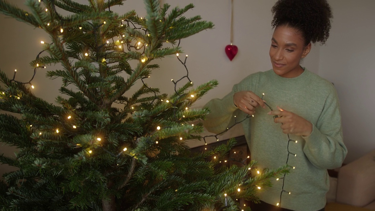 女人在家里为节日庆祝装饰圣诞树视频素材