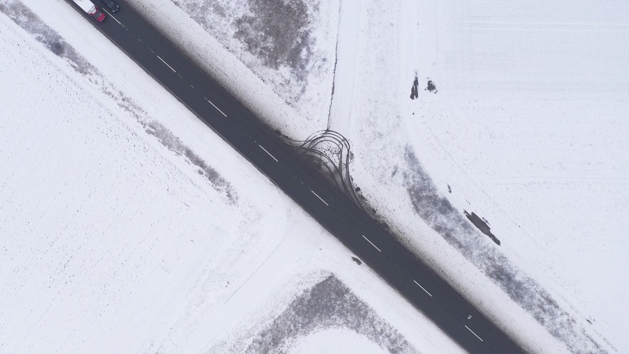 鸟瞰图的汽车在冬季道路上，乡村景观覆盖积雪视频素材