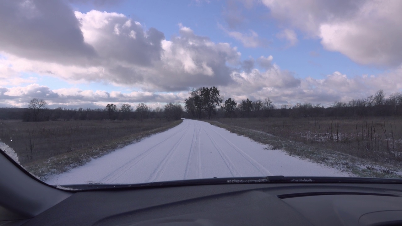 从一辆行驶在白雪覆盖的道路上的汽车上看到的景色。视频素材