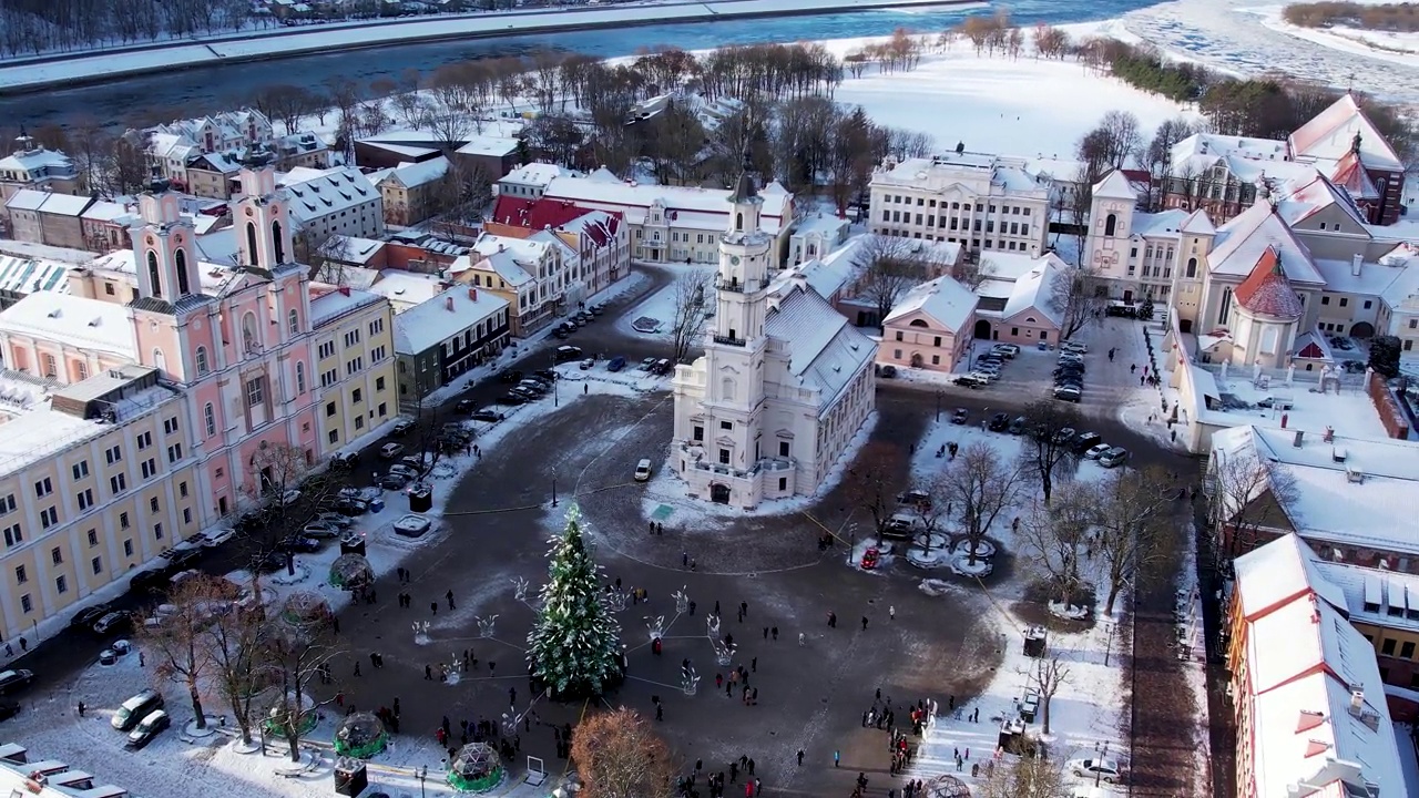 空中4K旋转镜头雪考纳斯老城区的圣诞树和市场在市政厅广场视频素材