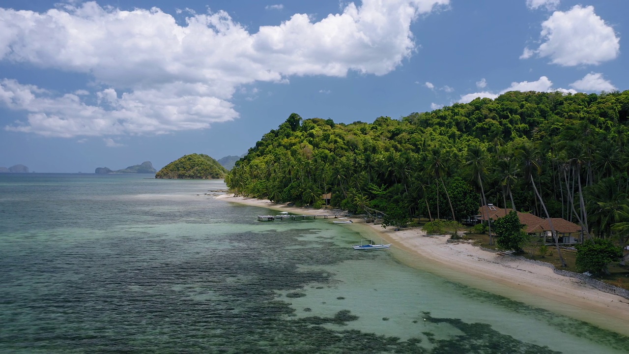 在菲律宾巴拉望岛的El Nido，一架4k无人机沿着异国情调的热带海滩飞行，浅水里有班卡船，还有椰子树。夏天和旅游度假的概念视频素材