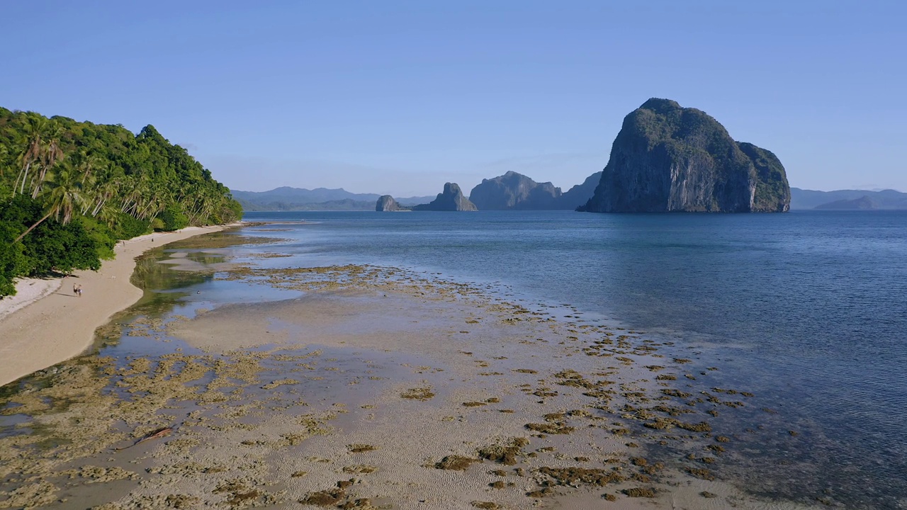 4k鸟瞰图，El Nido，巴拉望，菲律宾。退潮时停泊在浅水处的班卡船。背景是岛屿的热带海滩视频素材