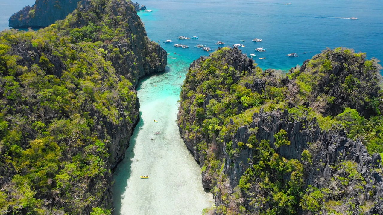 大泻湖，El Nido，巴拉望，菲律宾。无人机在入口处浅水上方的石灰岩悬崖之间飞行。最受欢迎的跳岛游A视频素材