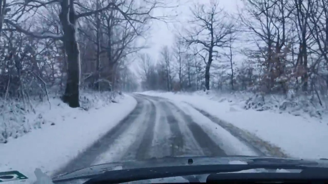 汽车观点。在冬天的雪地里，在土路上开车度假。视频素材