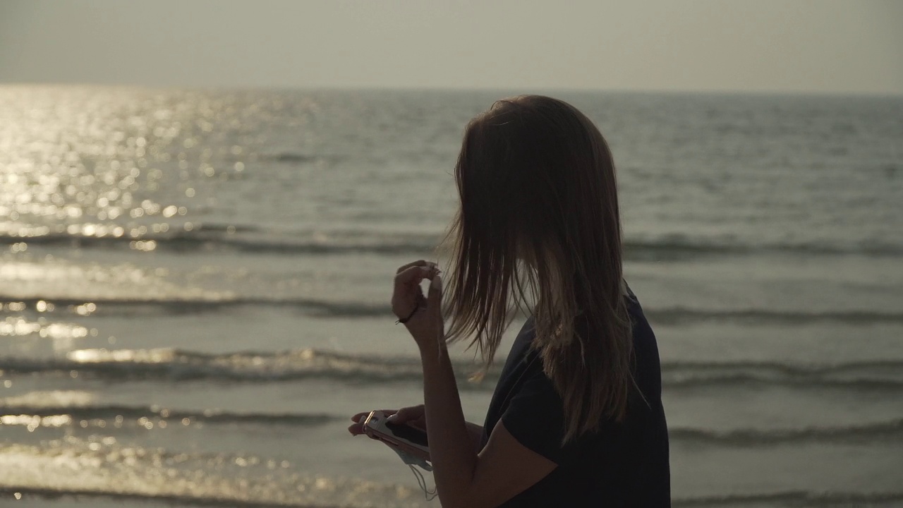 年轻的白人女孩看着海上的夕阳视频下载