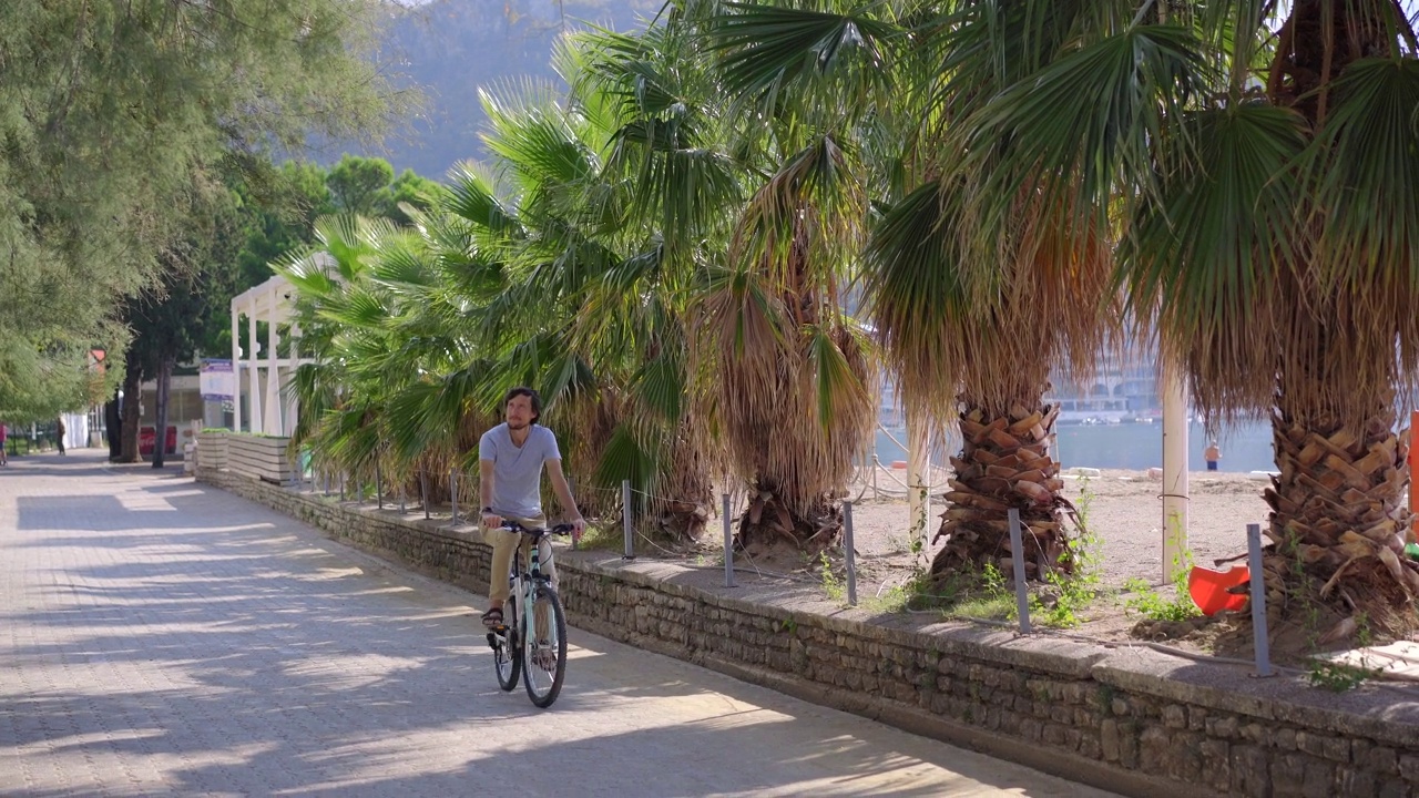 在黑山著名的旅游胜地布德瓦市，一名年轻人骑着自行车。黑山之旅视频素材