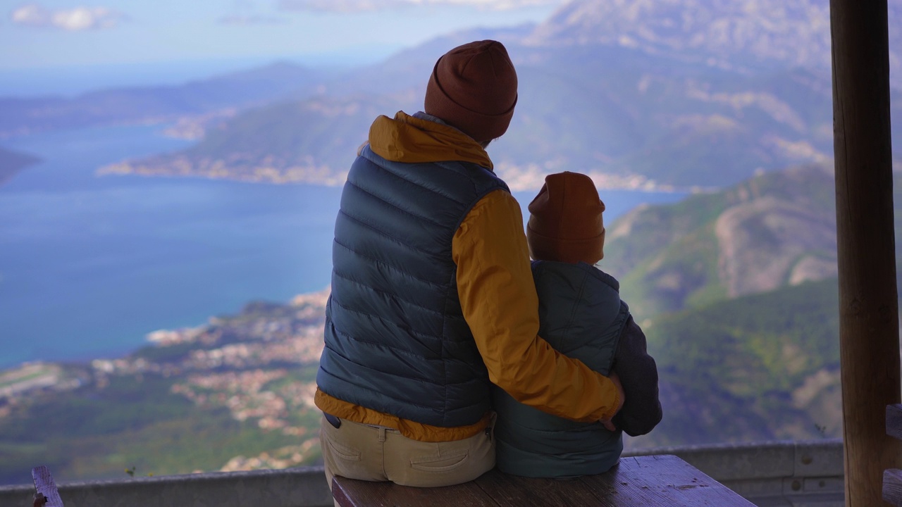 秋天，一对父子在黑山旅行。他们从山上的一个观景台俯瞰博卡科托斯卡湾视频素材