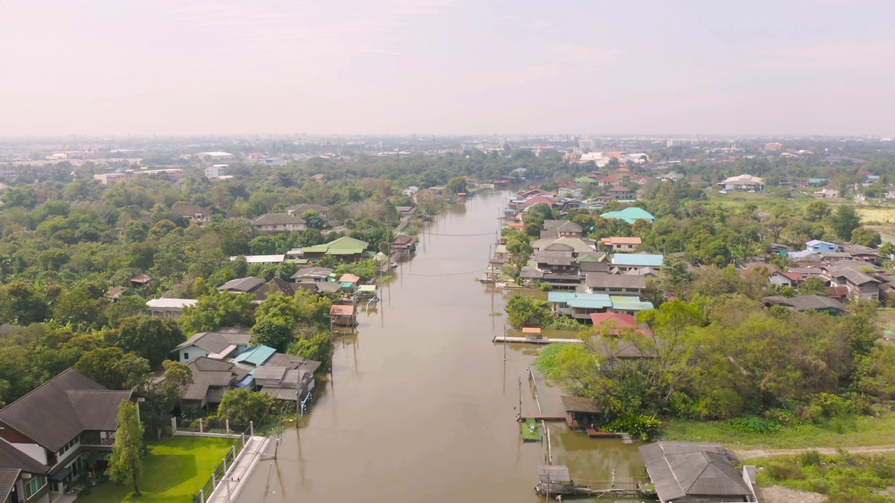 鸟瞰当地住宅与Phasi Charoen，湄南河或运河，自然树木，Nonthaburi市，泰国在亚洲的城市城镇，建筑。视频素材