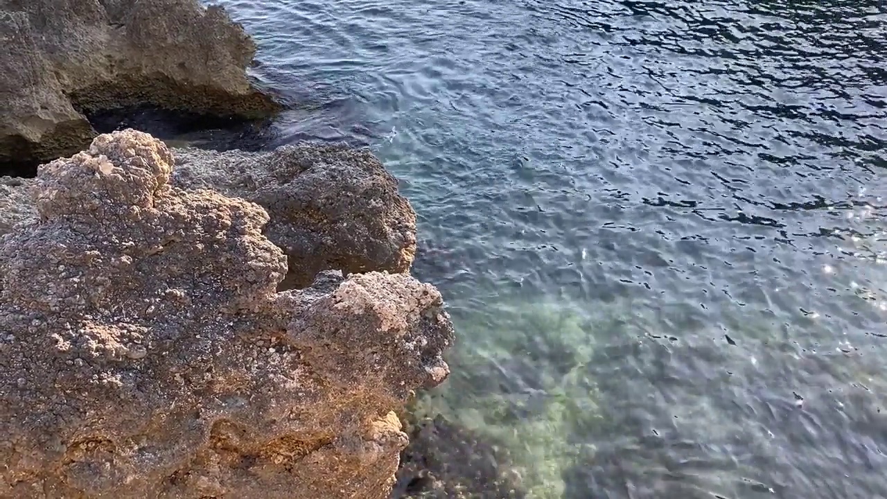 蓝绿色的海水波纹背景。透明的绿色海水表面在热带天堂泻湖。美丽的海景。地中海沿岸岩石嶙峋，海水平静。禅。放松。大自然。视频素材