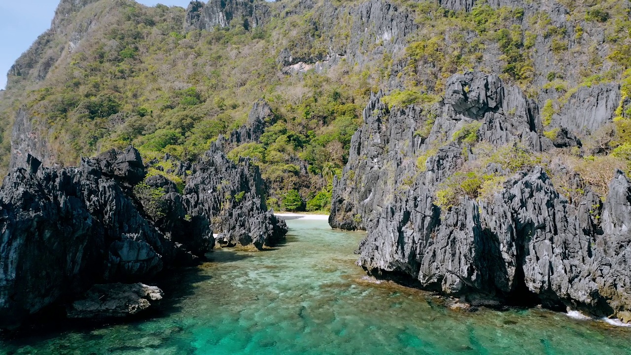 无人机俯瞰热带珊瑚礁和岩石岩层隐藏的海滩，El Nido Palawan国家公园视频素材