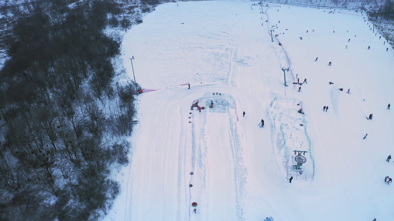 滑雪者和单板滑雪者在周末滑雪坡道与滑雪缆车:无人机建立拍摄视频素材