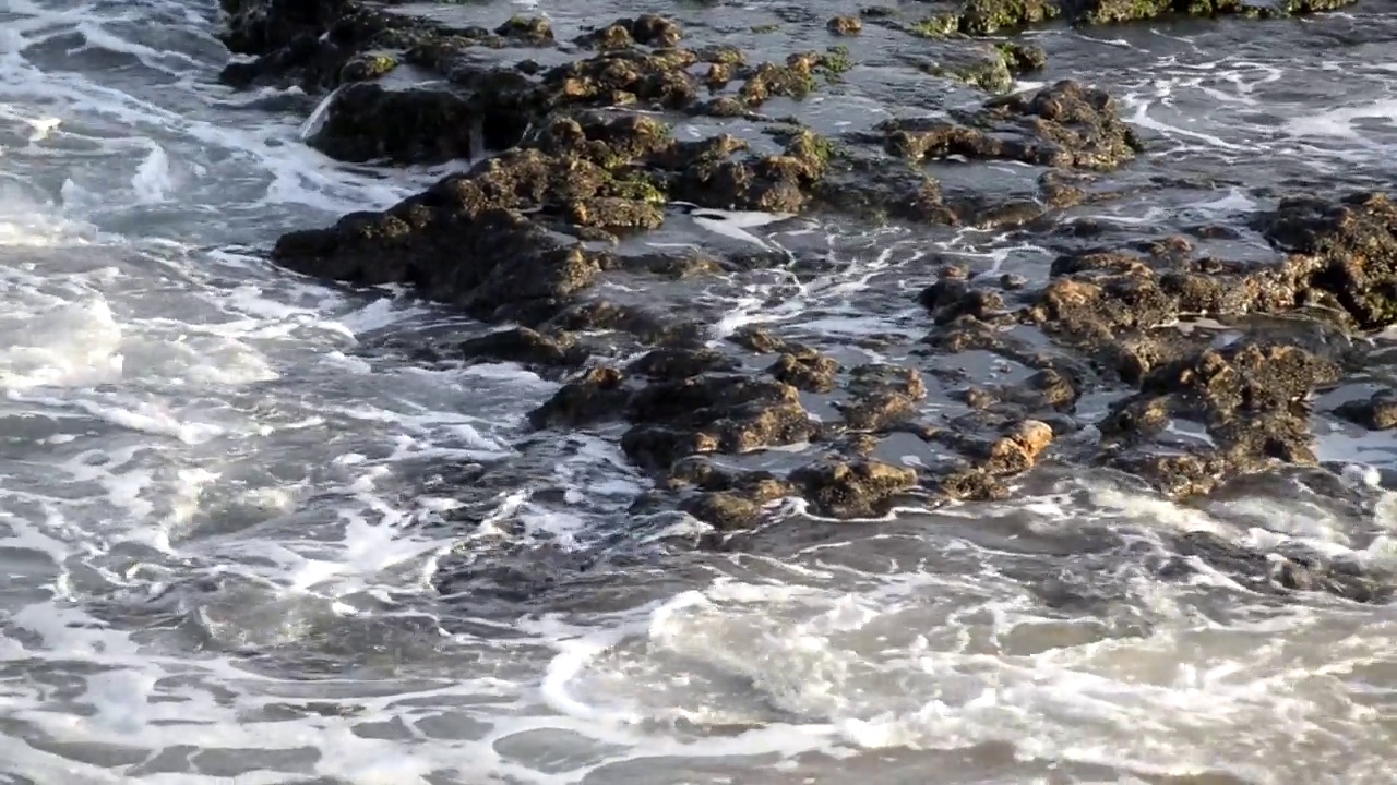 海浪拍打着维梅洛海滩的沙子和石头视频下载