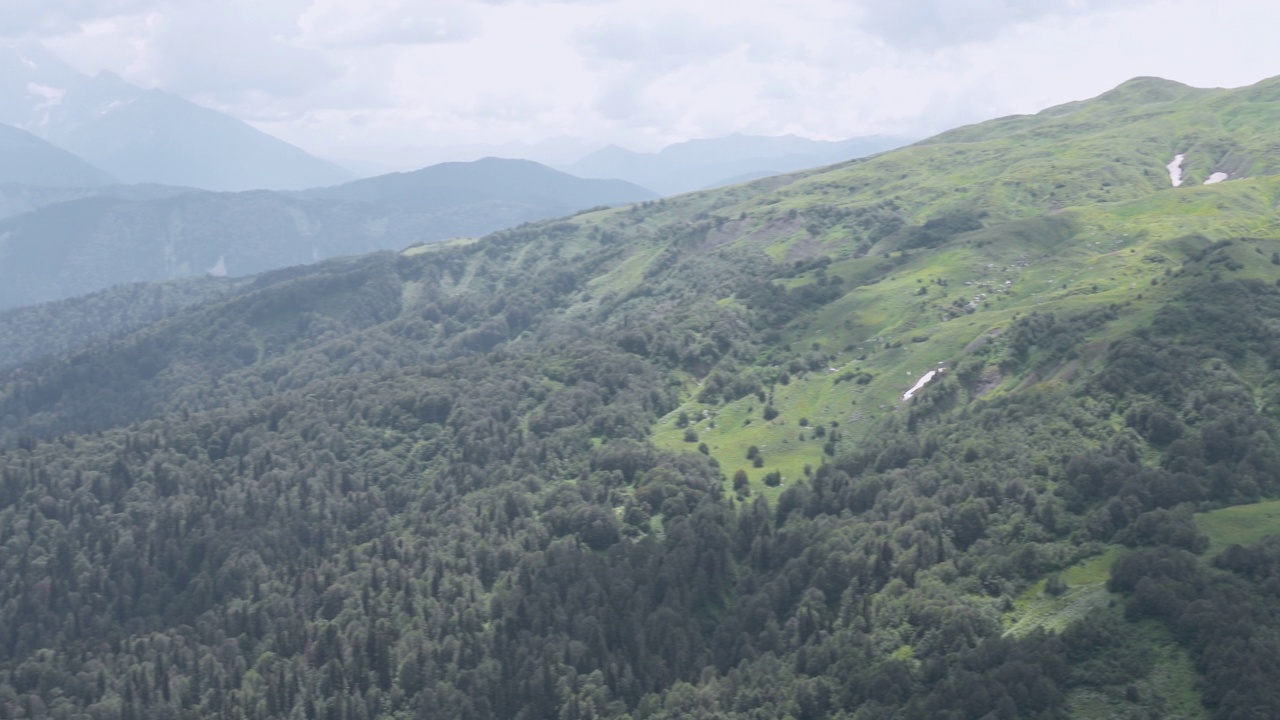 有绿色山谷的山地景观。群山在天空衬托下的剪影。视频素材