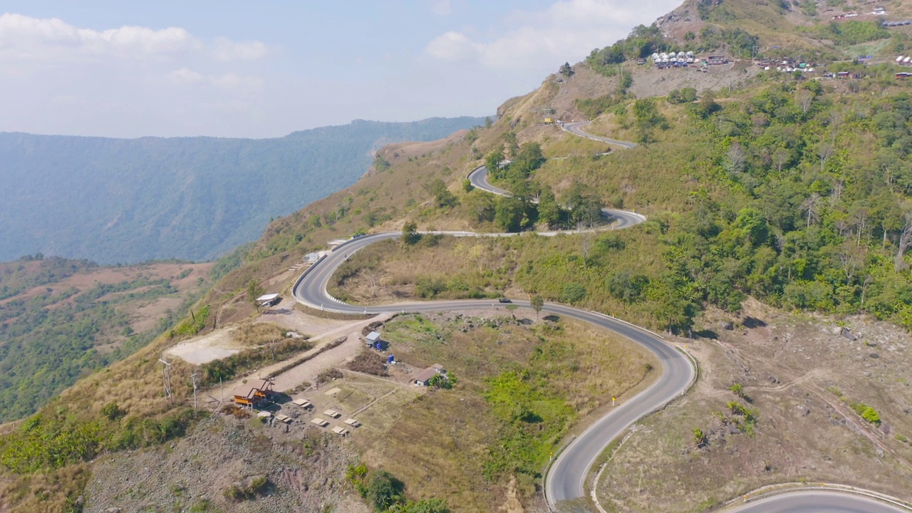 鸟瞰图，汽车行驶在弯曲的，曲折的弯曲的道路或街道上，山上有绿色的天然森林树木，泰国南部的农村地区。交通工具。视频素材