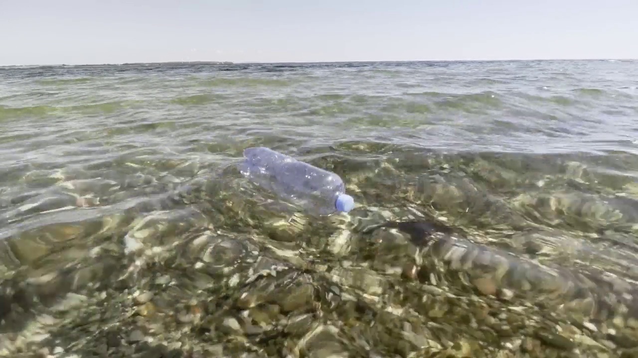 塑料瓶漂浮在海里视频素材