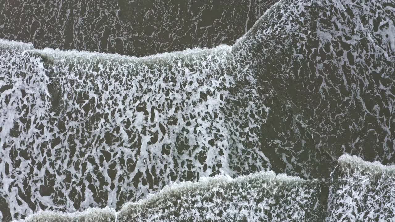 海浪撞击海岸的特写，留下了泡沫视频素材