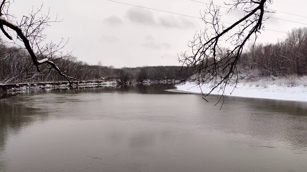 河流在冬季和雪花飘落时穿过俄罗斯克拉斯诺达尔地区的森林视频素材