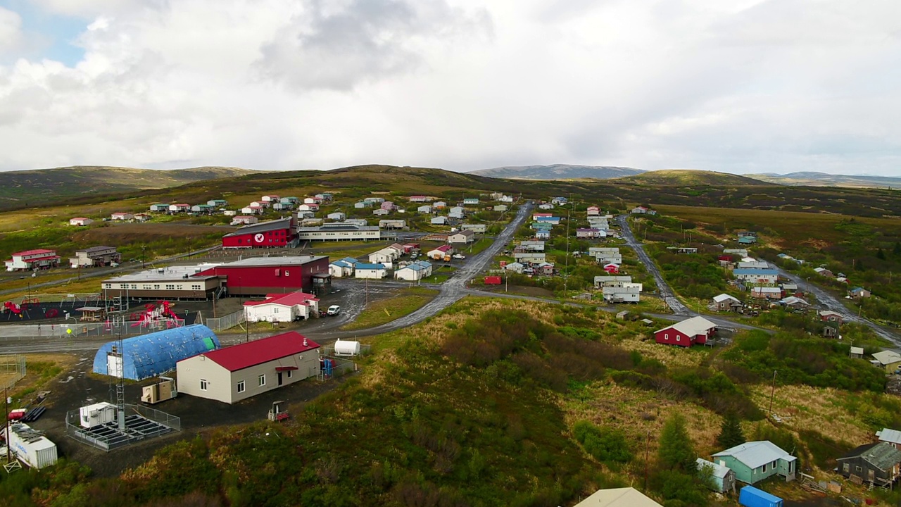 空中向前拍摄的住宅在绿色景观的山对着多云的天空-圣玛丽，阿拉斯加视频素材