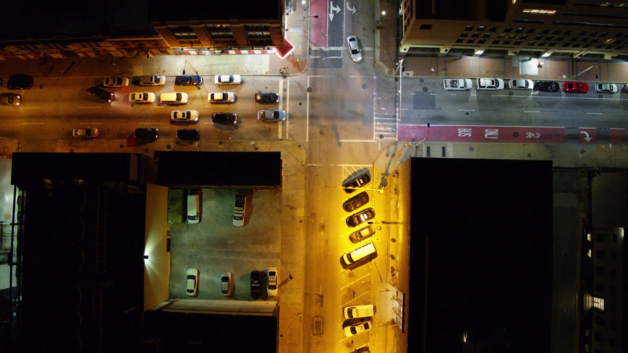 空中顶向后拍摄的汽车在城市夜间照明道路上移动-巴尔的摩，马里兰州视频素材