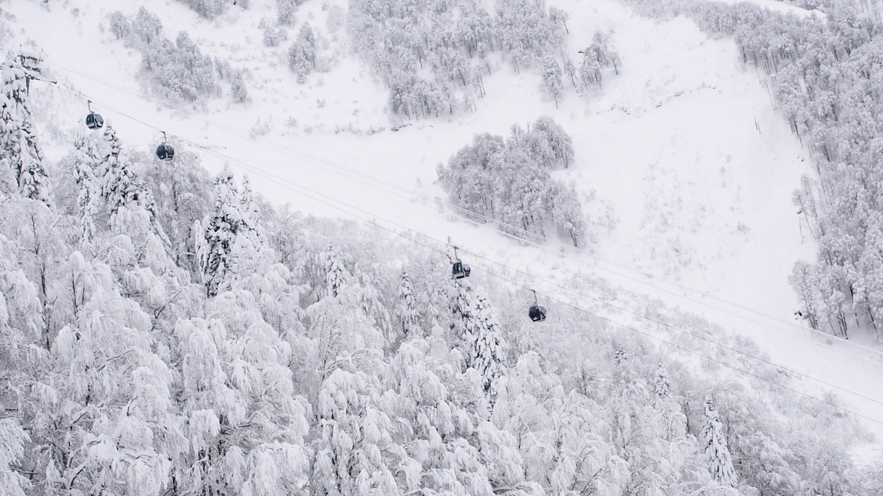 山区冬季景观缆车运动。翻过高山，森林，山坡。滑雪胜地。雪中的树视频下载