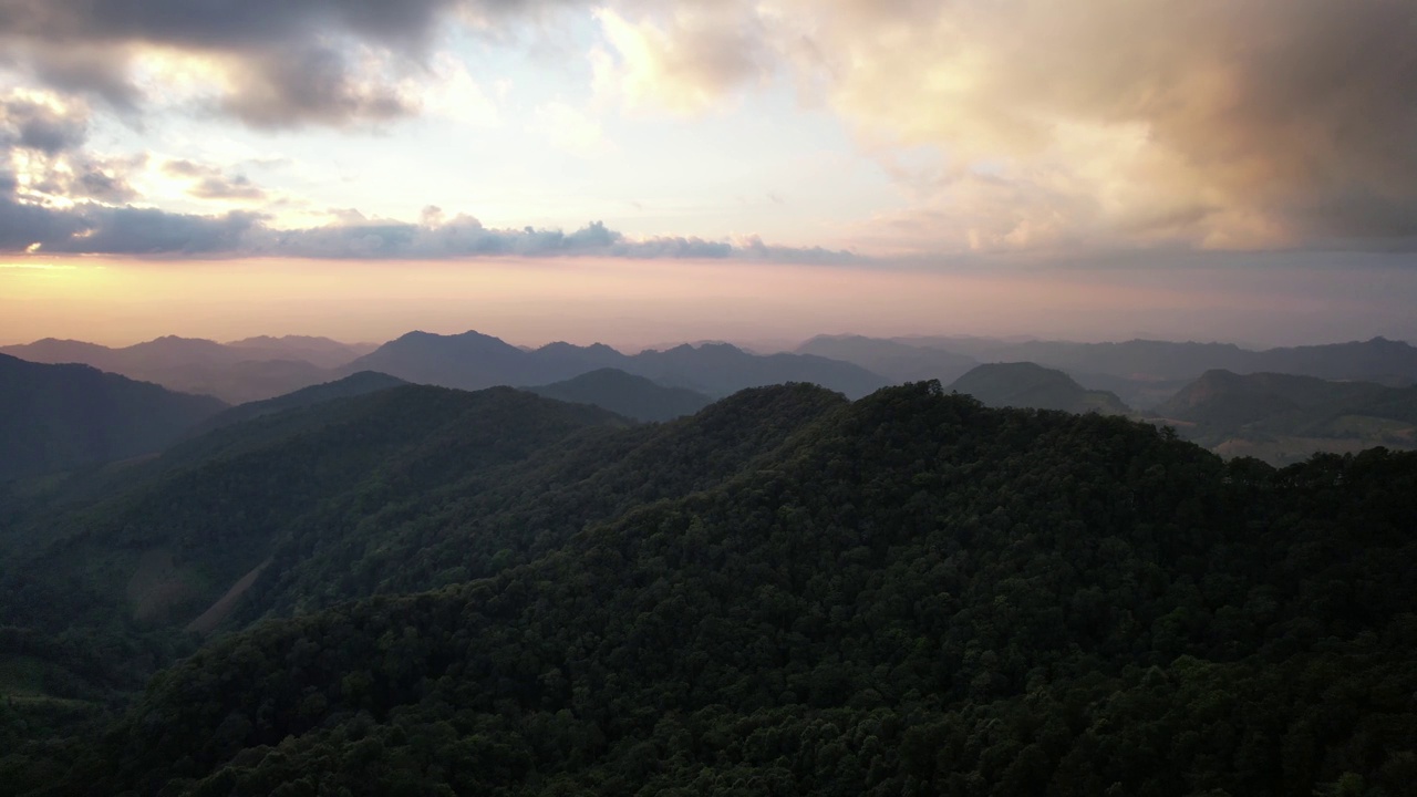 无人机在日落前的绿色雨林山脉的空中景观视图视频素材