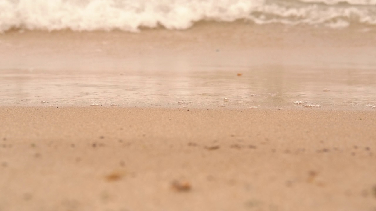 海浪冲刷着温暖的沙滩。视频素材