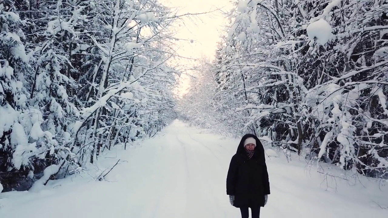 一个女人走在雪林里视频素材