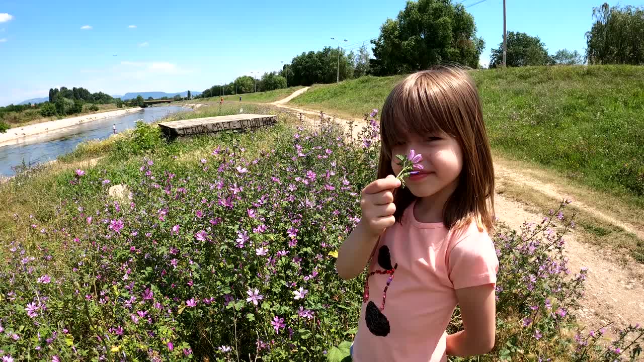 一个小女孩正在河边的公园里玩耍视频素材