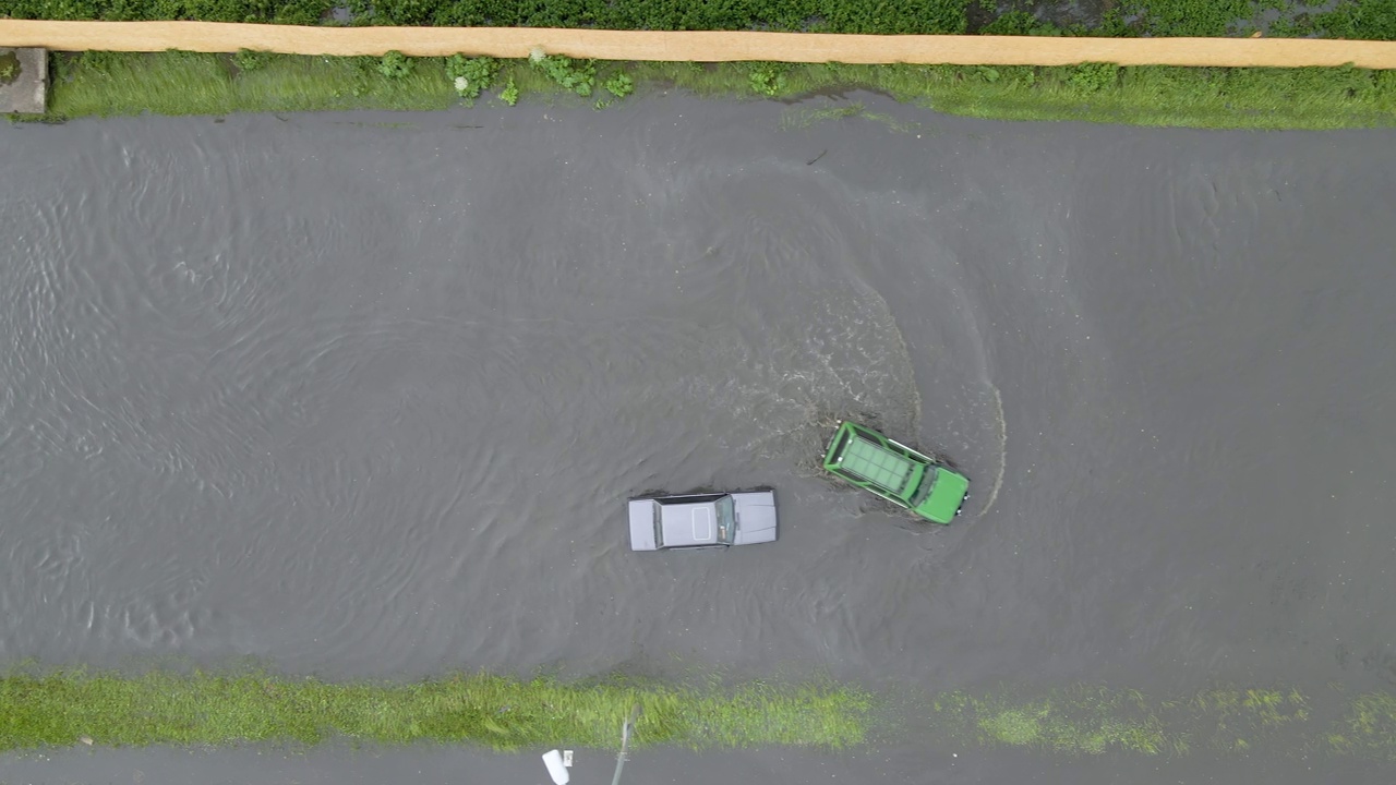 城市交通鸟瞰图，汽车行驶在暴雨后被淹没的街道上。道路排水系统的问题视频素材