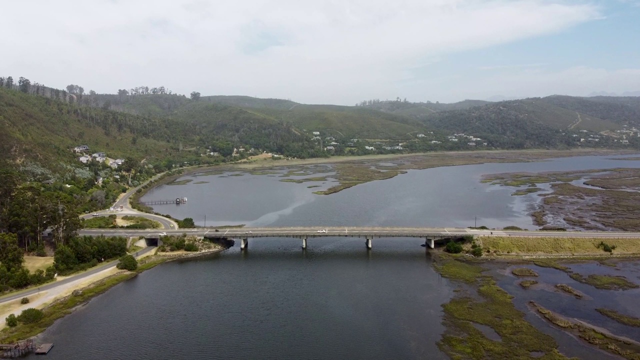 混凝土桥横跨河流，车辆在桥上行驶视频素材