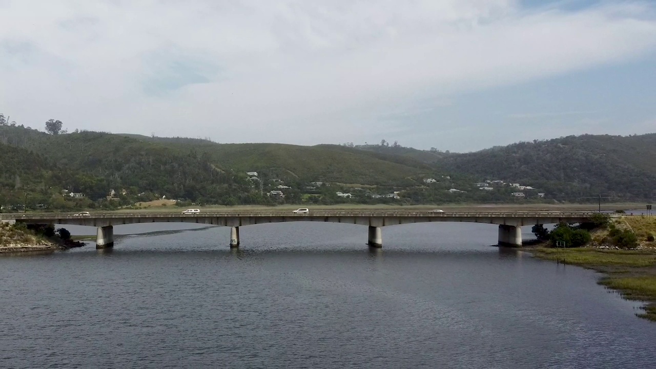 混凝土桥横跨河流，车辆在桥上行驶视频素材