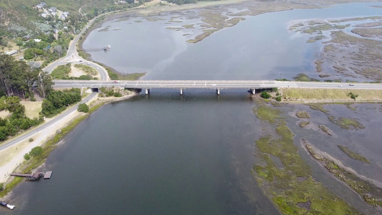 混凝土桥横跨河流，车辆在桥上行驶视频素材