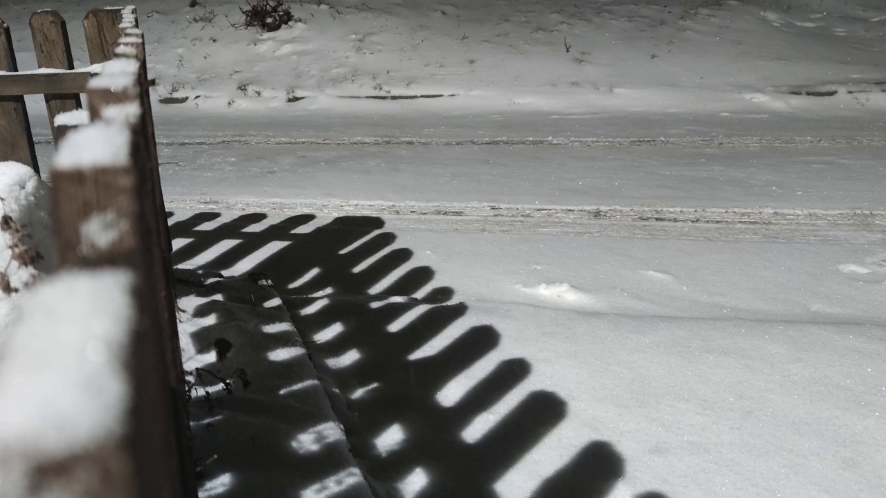 晚上公园里下雪了。安静的街道，没有雪花飘落的人。季节性的概念。下雪的天气。视频素材