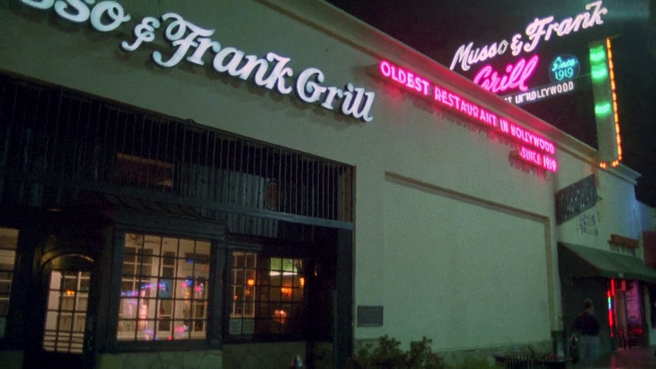 将餐厅入口的“musso & frank grill”招牌从右向左移至餐厅“musso & frank grill”上方的霓虹灯招牌。室内餐厅通过玻璃窗户和门。好莱坞的大街。视频素材