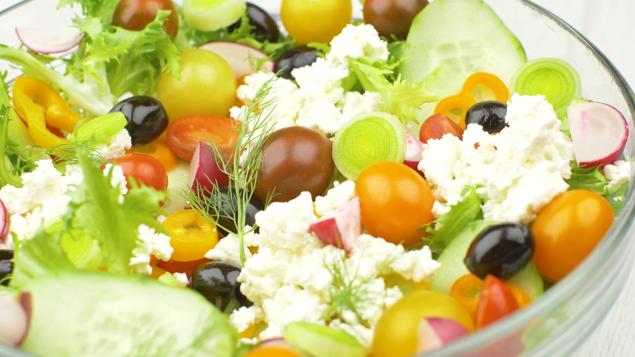 美味的混合沙拉配黄瓜，番茄，黑橄榄和羊乳酪视频素材