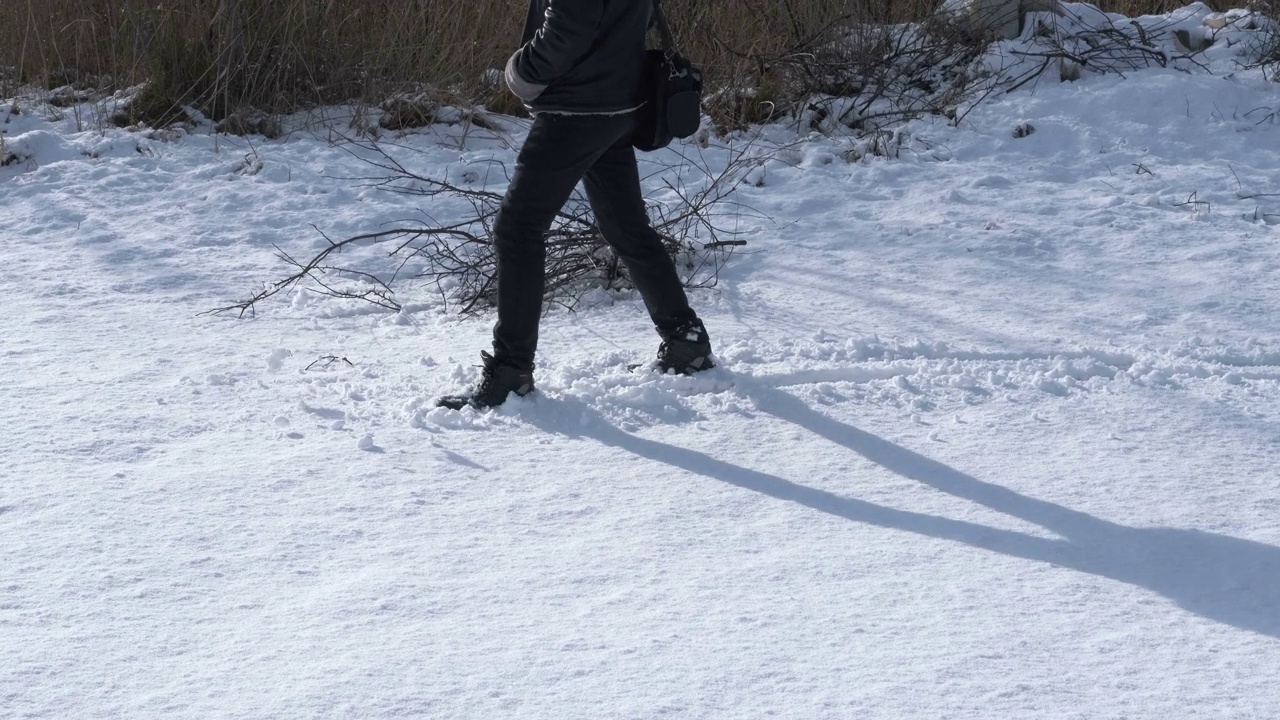 一个男人在冬天的雪地里行走视频素材